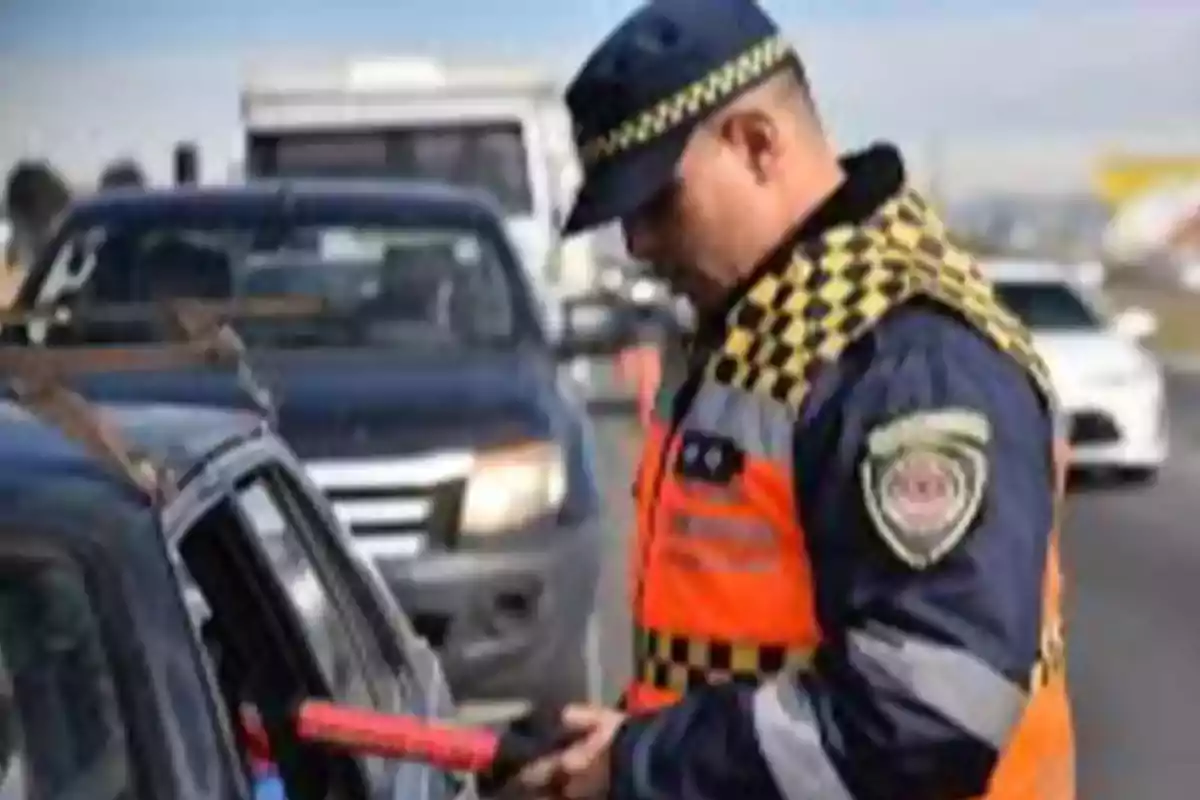 Oficial de tránsito revisando documentos de un conductor en un retén vial