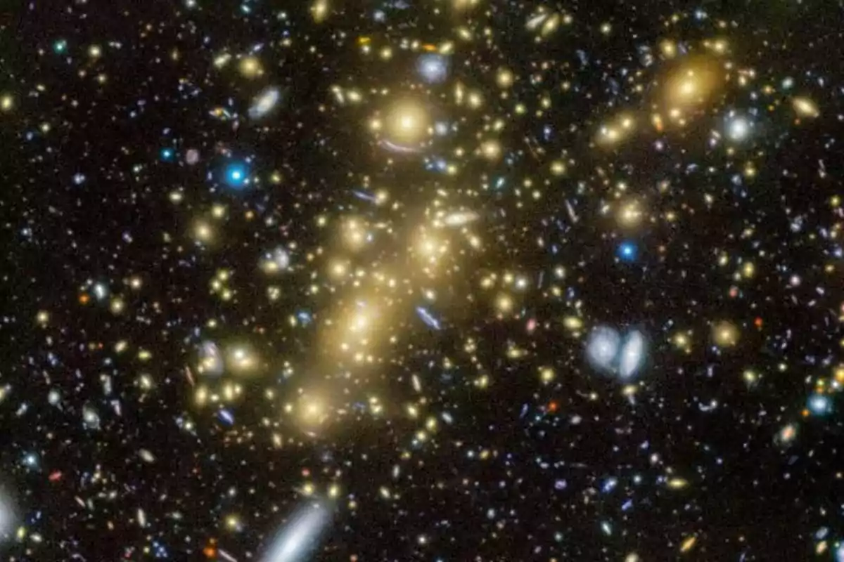 Image of a galaxy cluster in space with numerous points of light in different colors against a dark background Image of a galaxy cluster in space with numerous points of light in different colors against a dark background