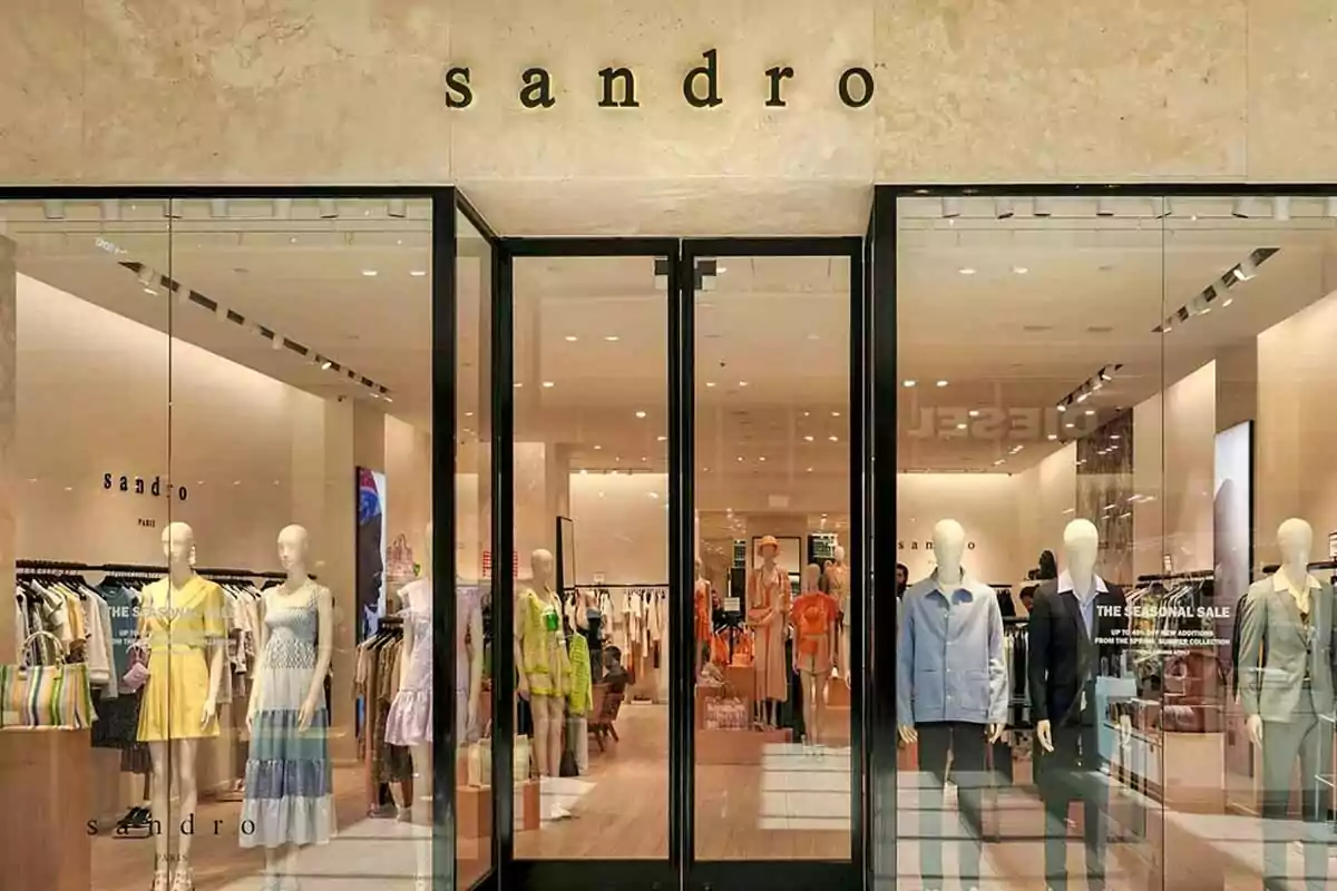 Fachada de una tienda de ropa Sandro con maniquíes vestidos con prendas de moda en el escaparate