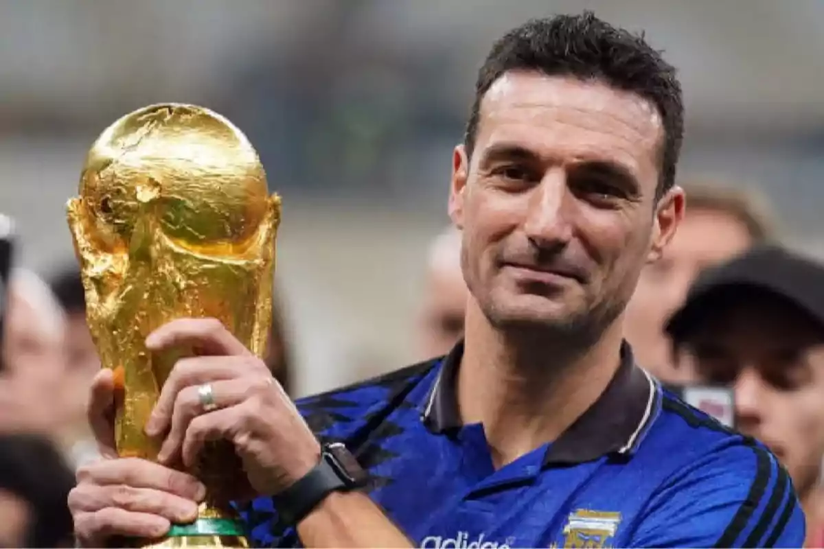 Hombre con camiseta azul de Argentina sosteniendo el trofeo dorado de la Copa del Mundo de fútbol y sonriendo Hombre con camiseta azul de Argentina sosteniendo el trofeo dorado de la Copa del Mundo de fútbol y sonriendo
