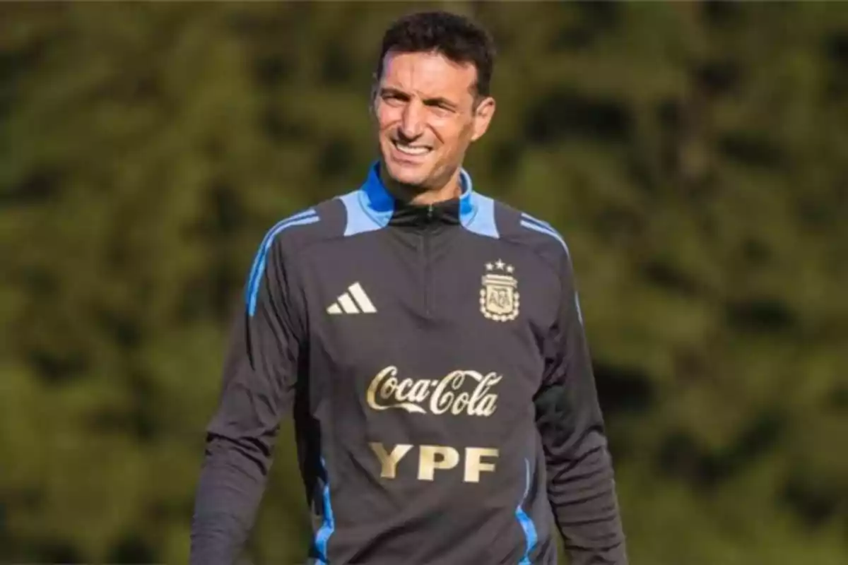 Entrenador de fútbol con ropa de la selección argentina sonríe al aire libre durante un entrenamiento
