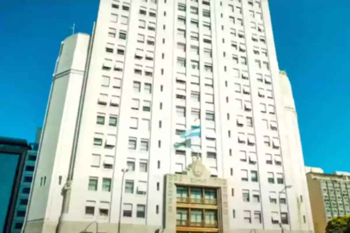 Tall Art Deco building with an Argentine flag waving in the front under a clear sky Tall Art Deco building with an Argentine flag waving in the front under a clear sky