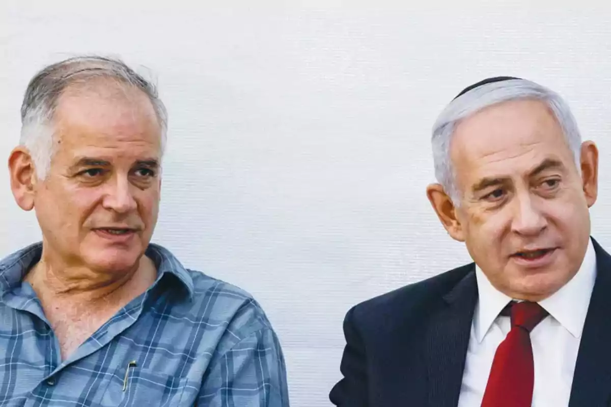 Two older men are sitting and talking; one is wearing a plaid jersey and the other is dressed in a dark suit with a red tie.