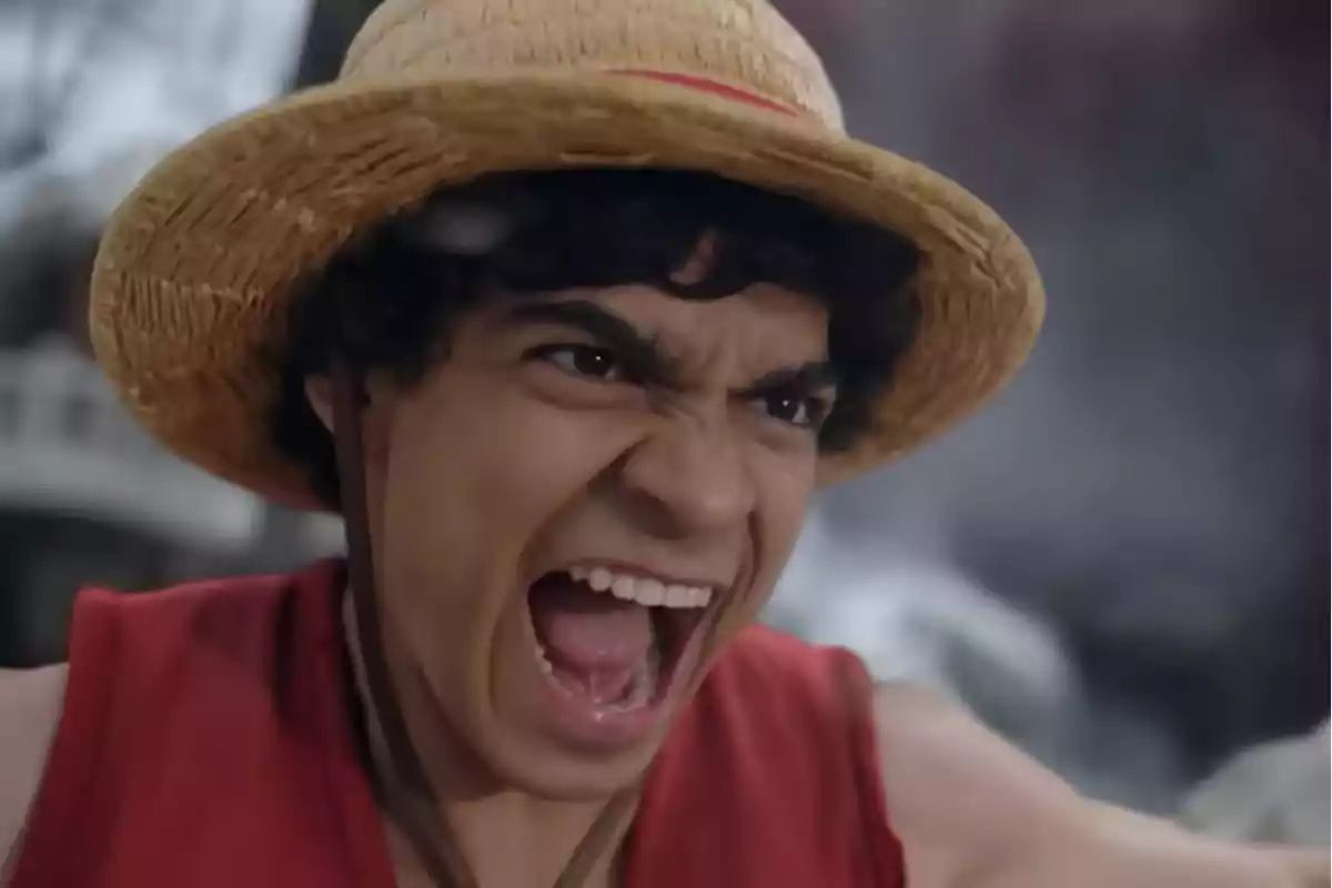 Joven con sombrero de paja y chaleco rojo gritando con expresión de determinación