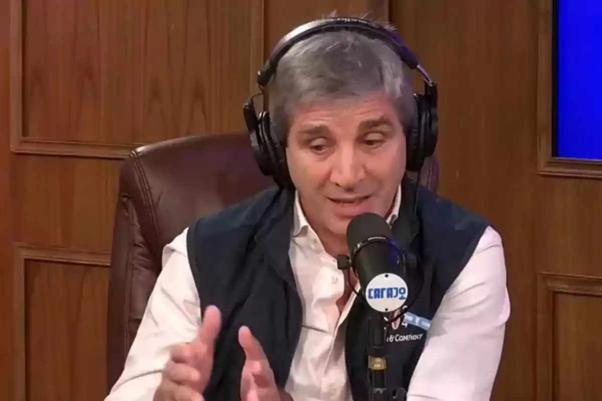 Hombre de cabello canoso usando audífonos y hablando frente a un micrófono en un estudio de radio