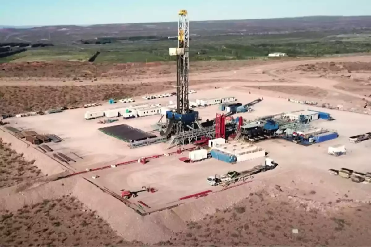 Vista aérea de una plataforma petrolera rodeada de equipos y vehículos en una zona árida