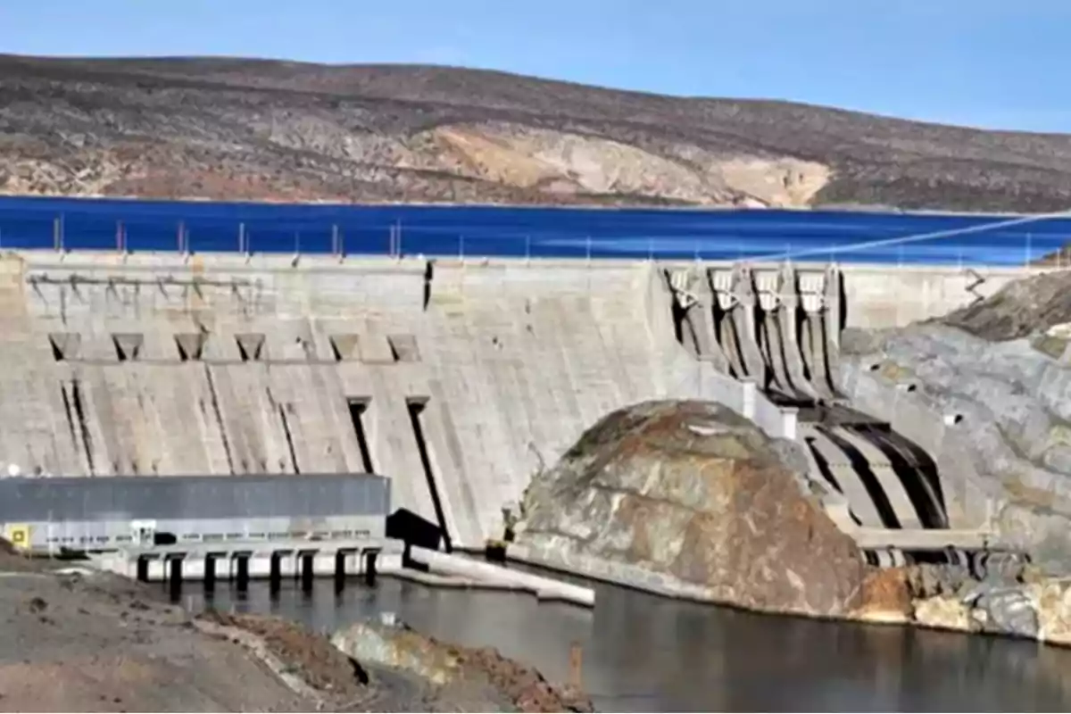 Presa de concreto con agua acumulada y paisaje árido al fondo Presa de concreto con agua acumulada y paisaje árido al fondo