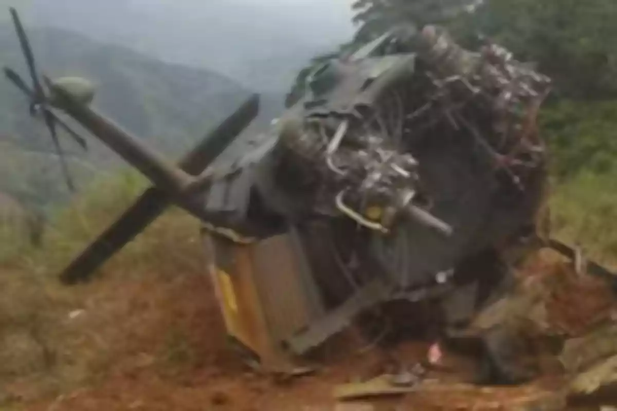 Helicóptero accidentado volcado sobre terreno inclinado en una zona montañosa Helicóptero accidentado volcado sobre terreno inclinado en una zona montañosa
