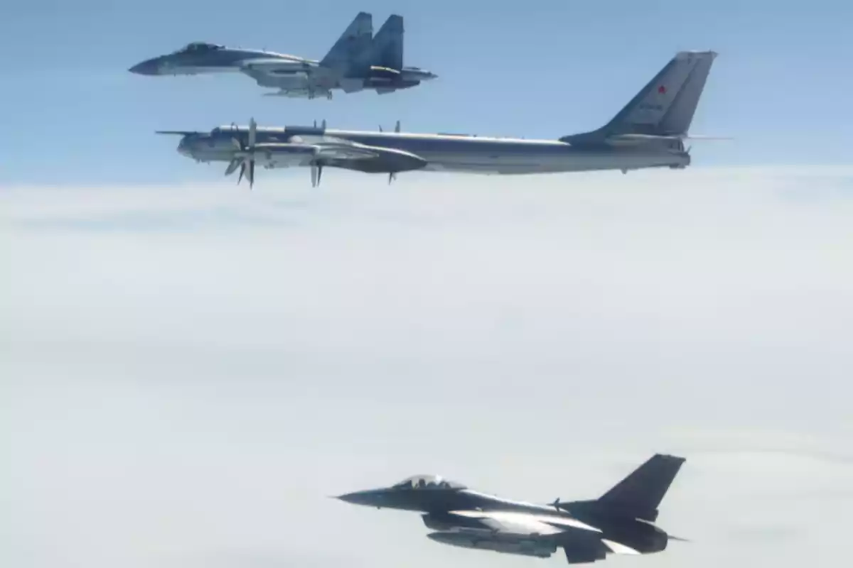 Tres aviones militares vuelan en formación sobre un cielo parcialmente nublado Tres aviones militares vuelan en formación sobre un cielo parcialmente nublado