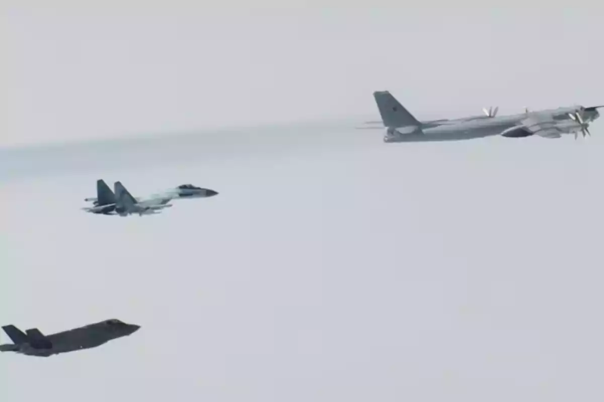 Tres aviones militares vuelan en formación sobre un cielo despejado Tres aviones militares vuelan en formación sobre un cielo despejado