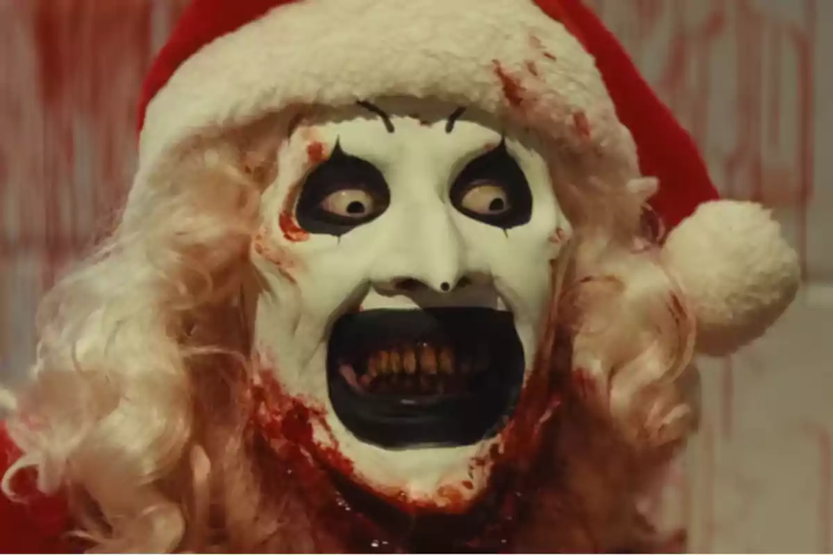 Payaso aterrador con maquillaje blanco y negro, gorro de Santa Claus, sangre en la cara y expresión de locura Payaso aterrador con maquillaje blanco y negro, gorro de Santa Claus, sangre en la cara y expresión de locura