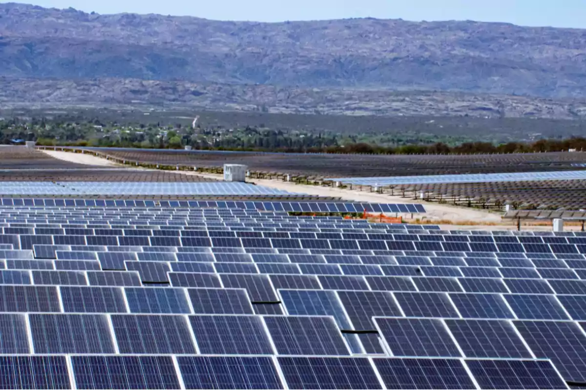 Large field of solar panels with mountains in the background on a sunny day Large field of solar panels with mountains in the background on a sunny day