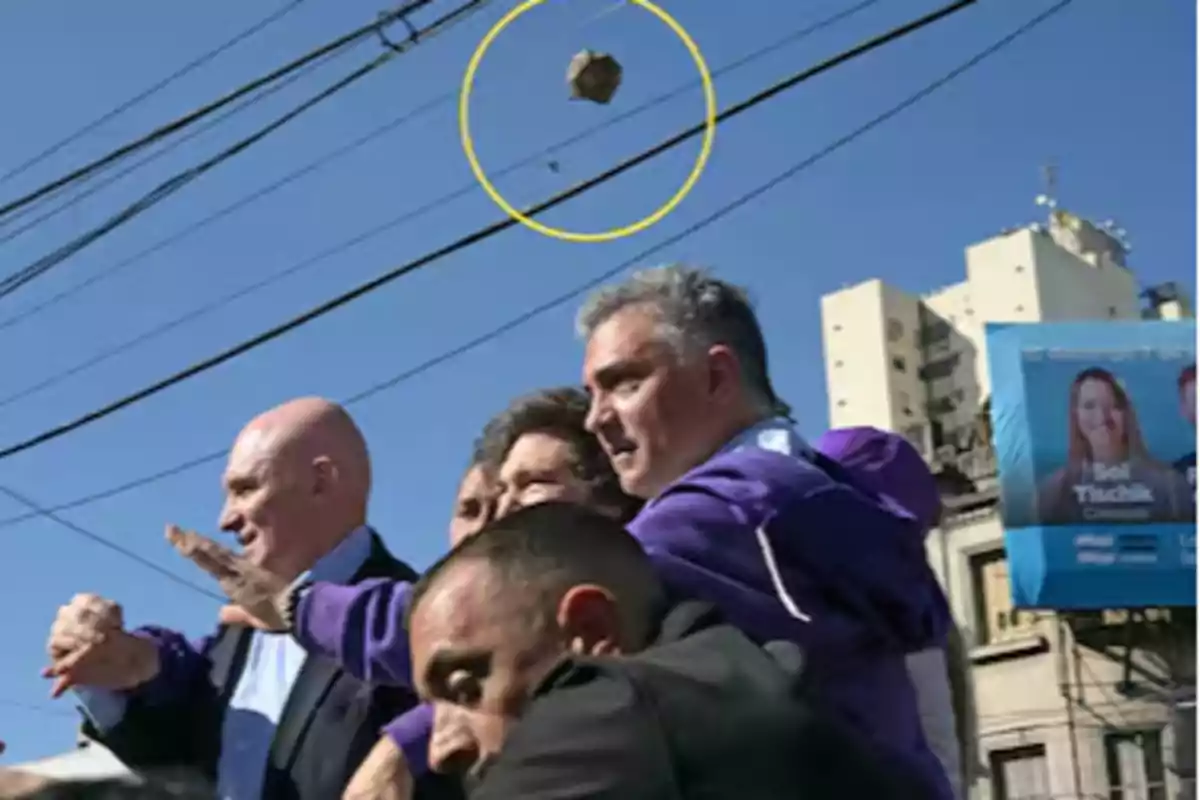A group of people on the street while a rock flies over them in the air A group of people on the street while a rock flies over them in the air