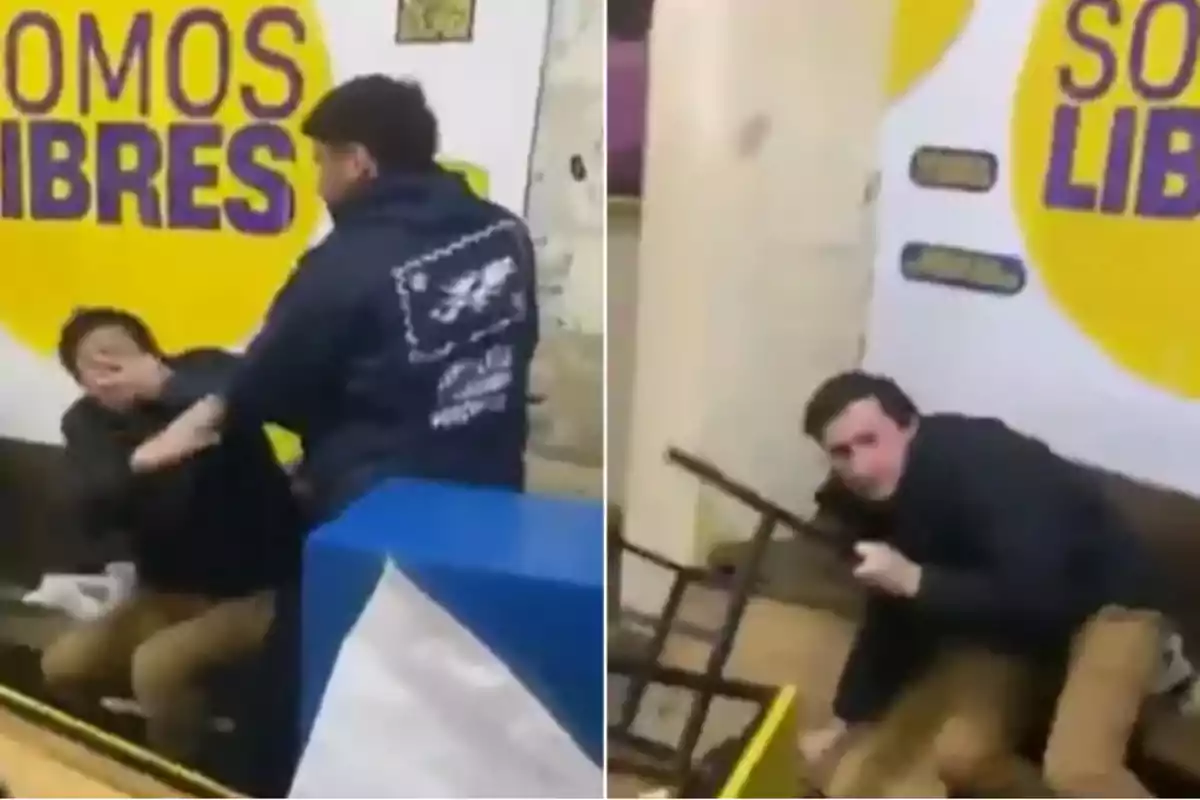 Two men argue and get into a physical altercation inside a place with yellow and purple signs that say Two men argue and get into a physical altercation inside a place with yellow and purple signs that say