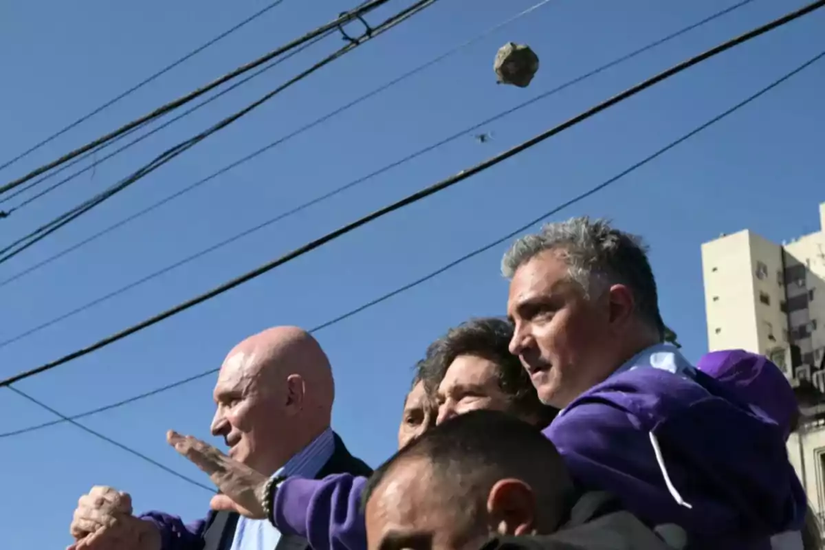 A group of people on the street with an object flying above them and power lines in the background