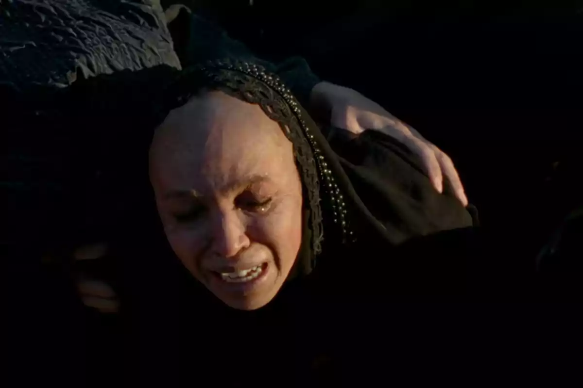 Woman in a black veil crying and being comforted by a hand on her shoulder Woman in a black veil crying and being comforted by a hand on her shoulder
