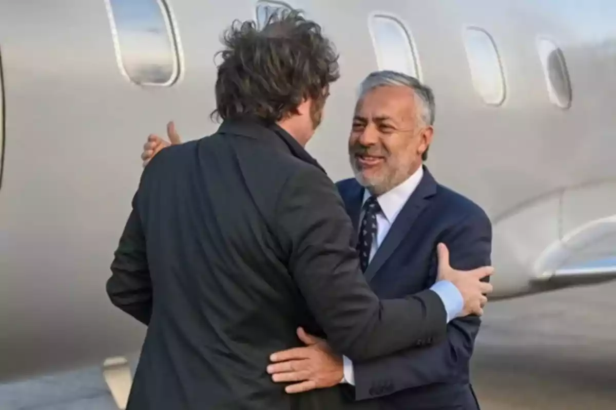 Two men in suits greet each other with a hug in front of a private jet. Two men in suits greet each other with a hug in front of a private jet.