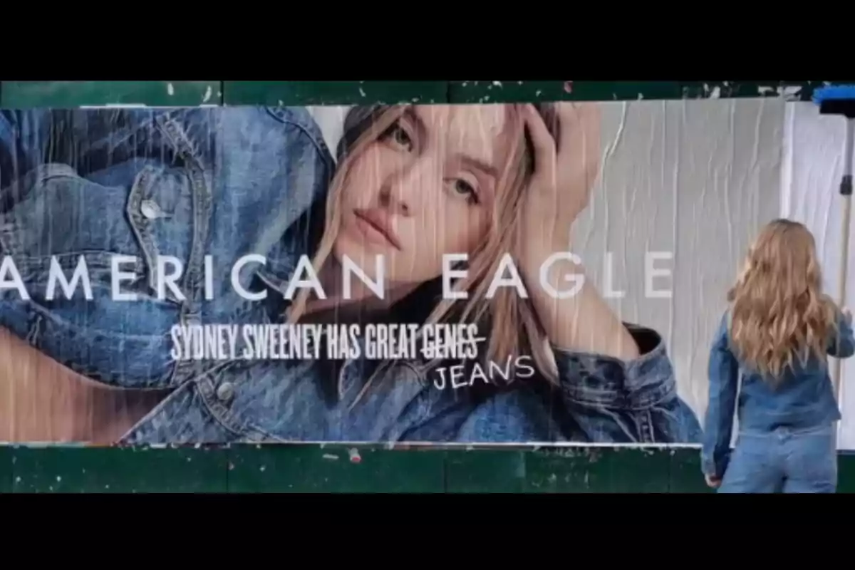 Una mujer de espaldas vestida con chaqueta y pantalón de mezclilla observa un cartel publicitario de American Eagle con una modelo rubia usando ropa de mezclilla y el texto Sydney Sweeney has great genes jeans. Una mujer de espaldas vestida con chaqueta y pantalón de mezclilla observa un cartel publicitario de American Eagle con una modelo rubia usando ropa de mezclilla y el texto Sydney Sweeney has great genes jeans.