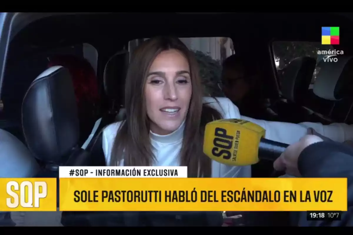 Mujer dando una entrevista desde el interior de un auto mientras sostiene un micrófono amarillo con el logo de SQP y en la pantalla aparece el texto Sole Pastorutti habló del escándalo en La Voz Mujer dando una entrevista desde el interior de un auto mientras sostiene un micrófono amarillo con el logo de SQP y en la pantalla aparece el texto Sole Pastorutti habló del escándalo en La Voz
