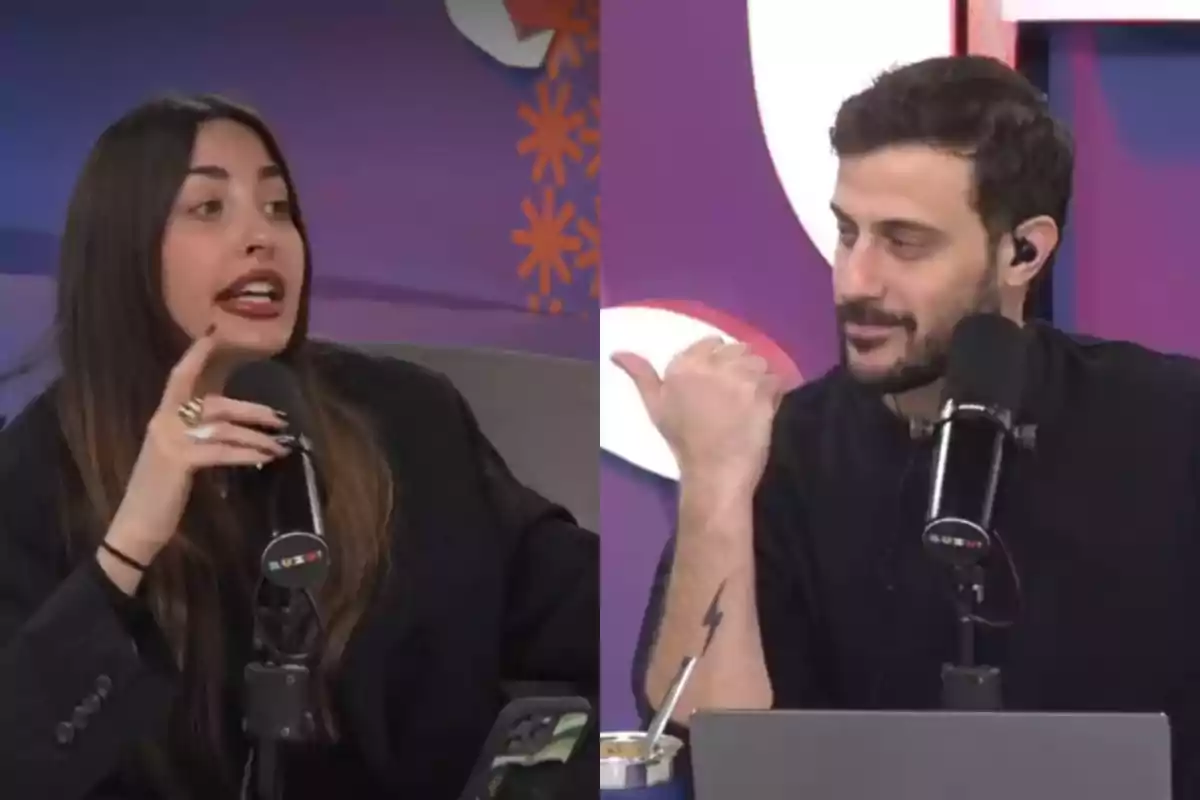 Two people are talking in front of microphones in a studio with a purple background; the woman gestures while the man watches her and smiles. Two people are talking in front of microphones in a studio with a purple background; the woman gestures while the man watches her and smiles.