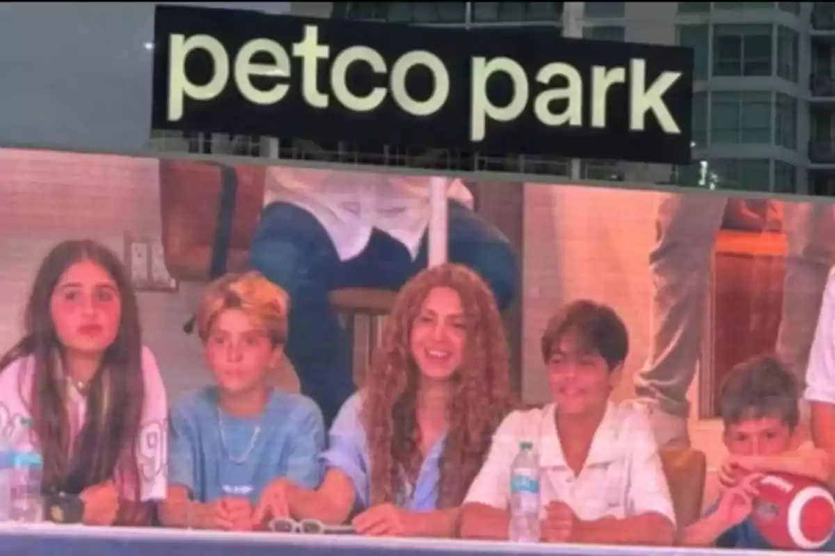 Cinco personas sentadas en una mesa aparecen en la pantalla gigante de un estadio con el letrero petco park arriba de ellas Cinco personas sentadas en una mesa aparecen en la pantalla gigante de un estadio con el letrero petco park arriba de ellas