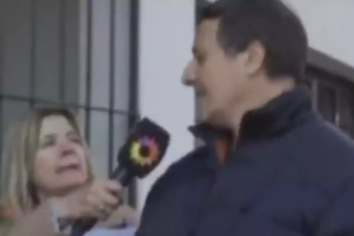 A reporter holds a microphone in front of a man during a street interview. A reporter holds a microphone in front of a man during a street interview.