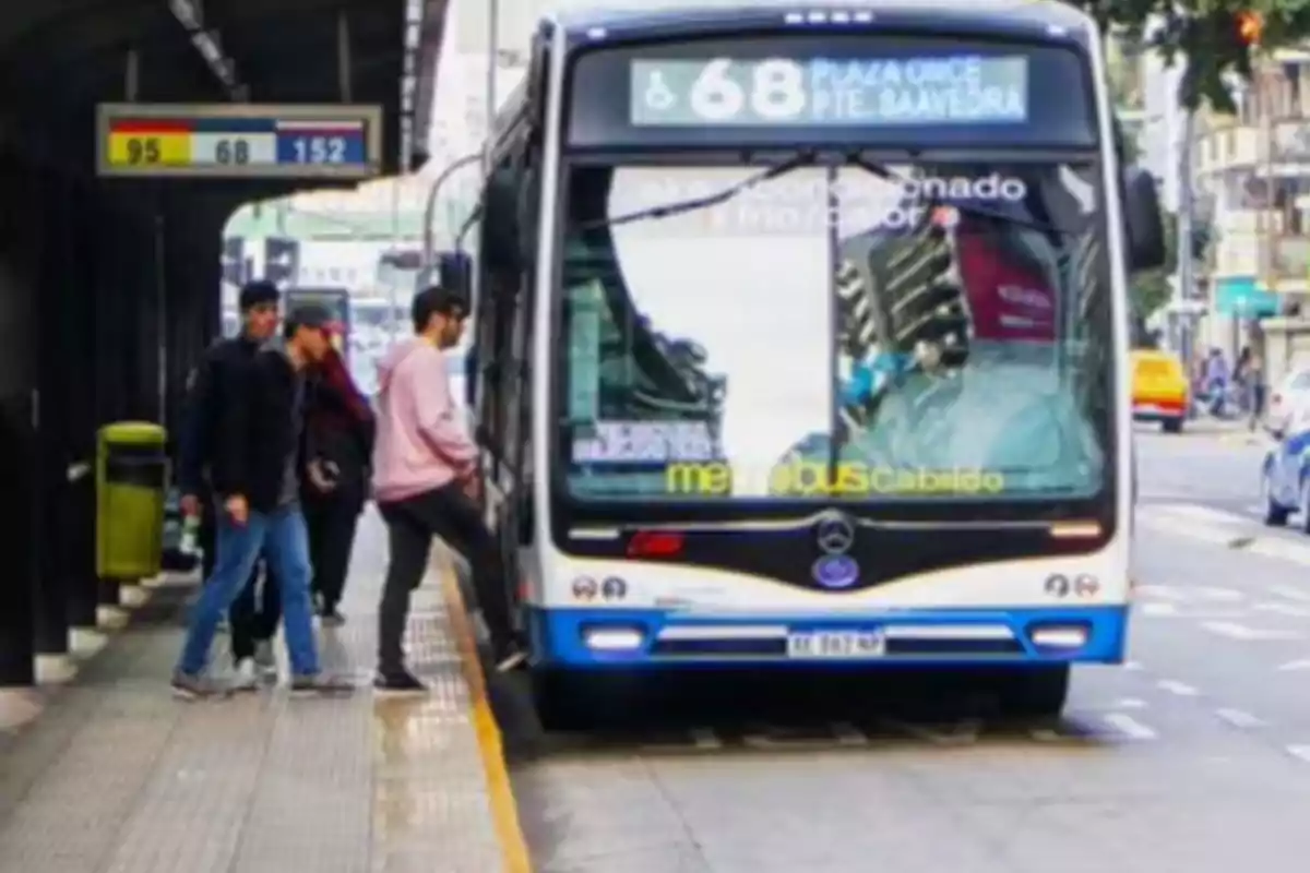 Personas subiendo a un colectivo en una parada de Metrobús en una ciudad