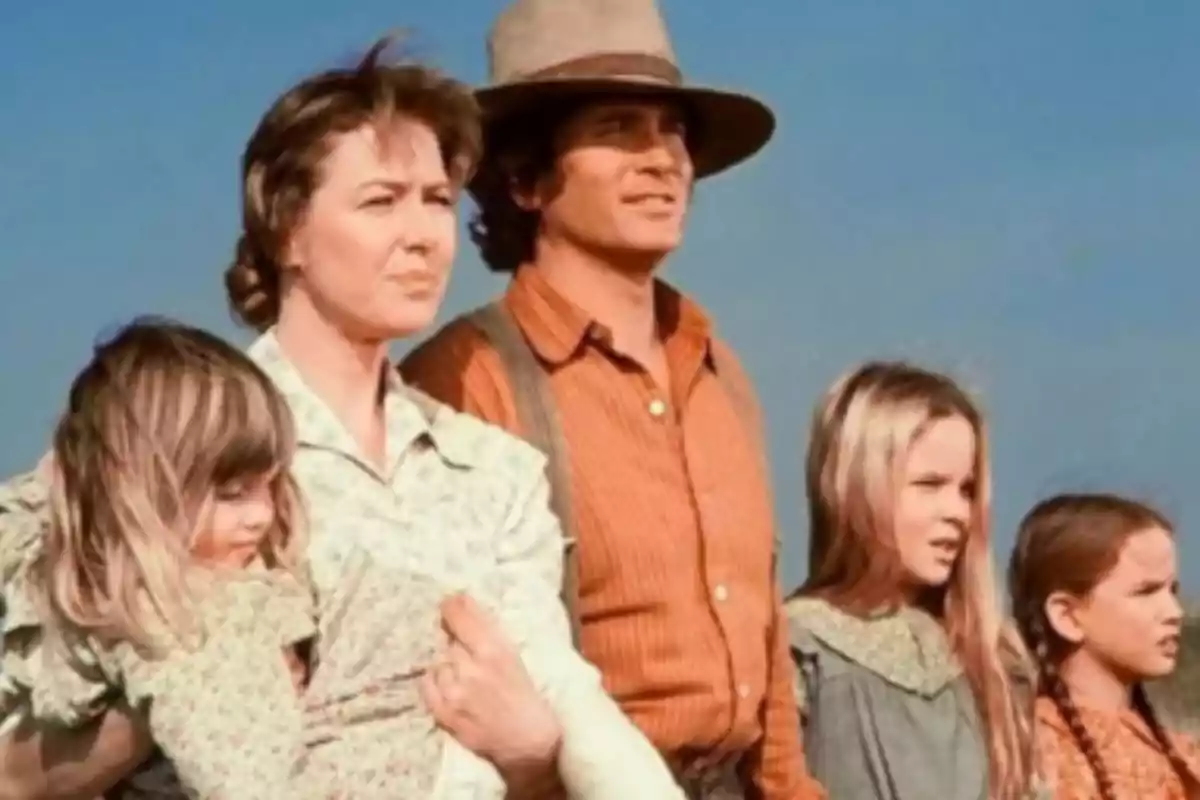 Family dressed in period clothing looking toward the horizon under a blue sky Family dressed in period clothing looking toward the horizon under a blue sky