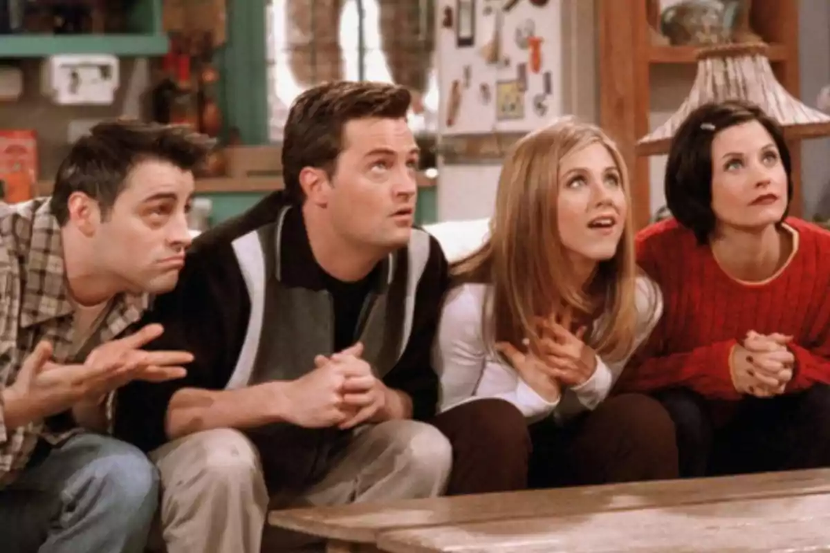Four people sitting on a couch, looking intently forward with expressions of anticipation. Four people sitting on a couch, looking intently forward with expressions of anticipation.