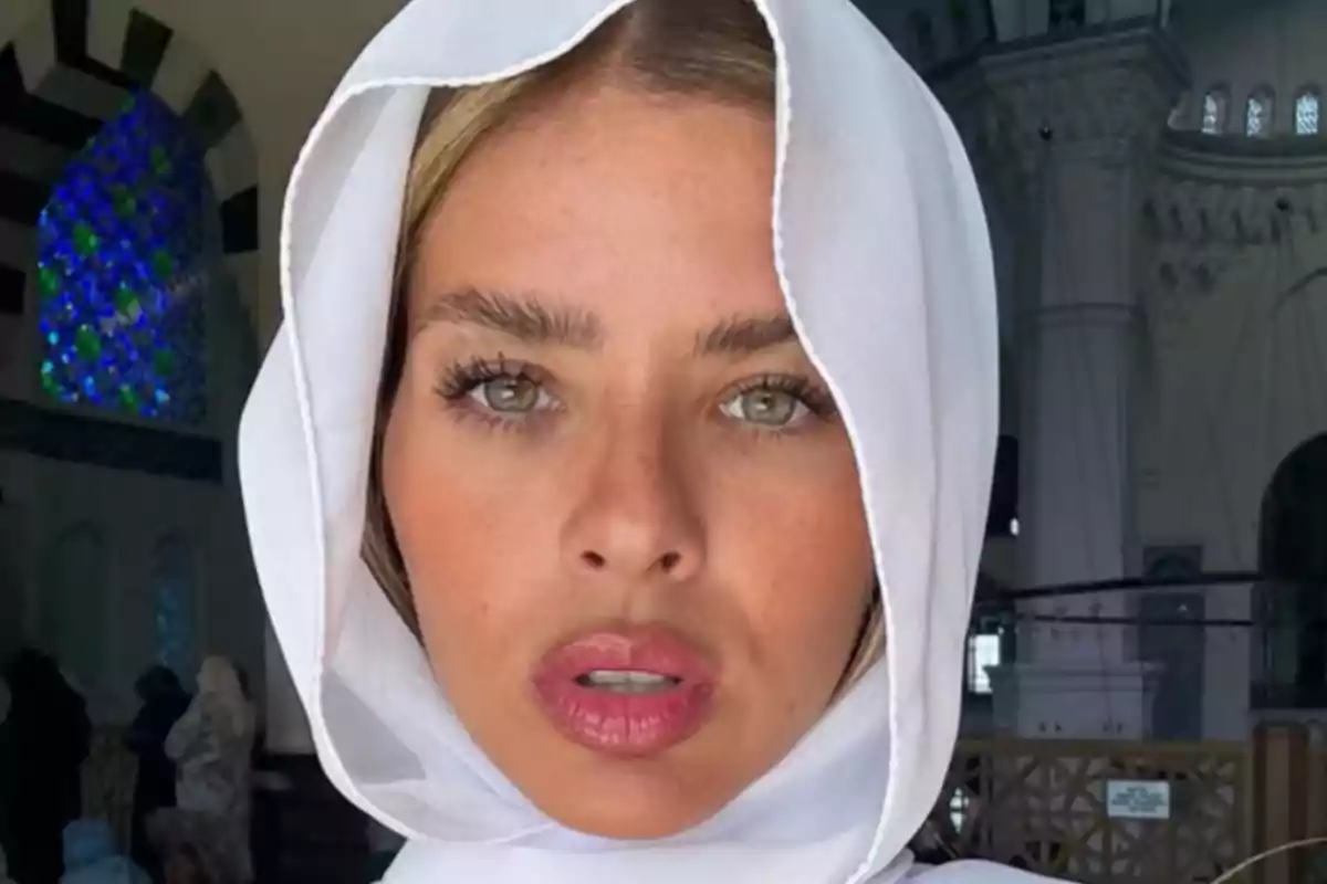 Woman with a white veil inside a building with colorful stained glass windows in the background