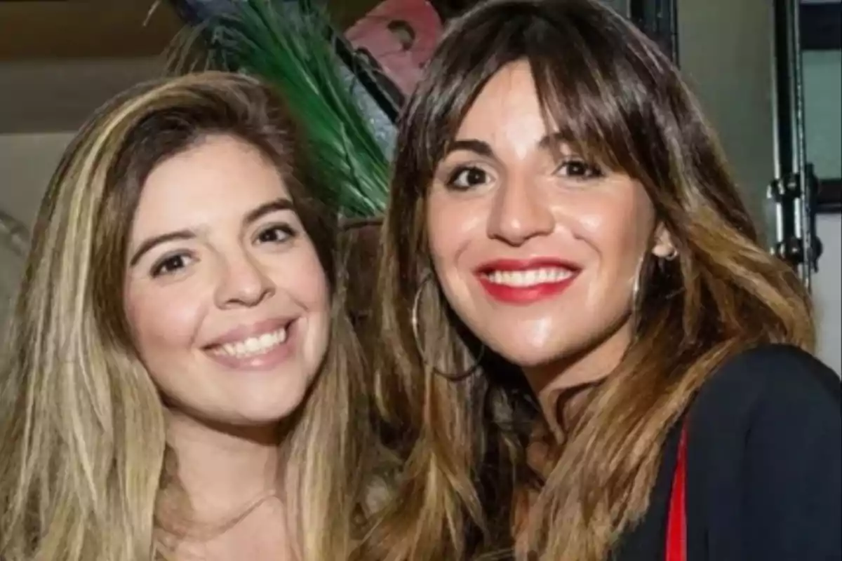 Two young women smile as they pose together for a photo in an indoor setting. Two young women smile as they pose together for a photo in an indoor setting.