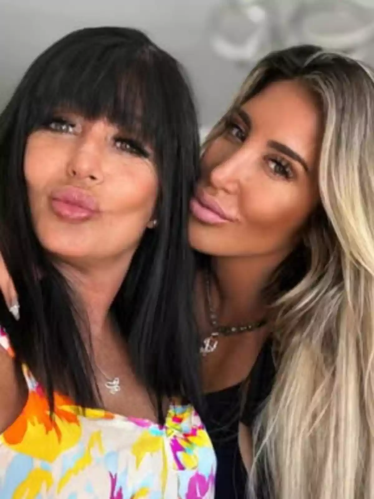 Dos mujeres posan juntas sonriendo y haciendo un gesto de beso mientras miran a la cámara Dos mujeres posan juntas sonriendo y haciendo un gesto de beso mientras miran a la cámara