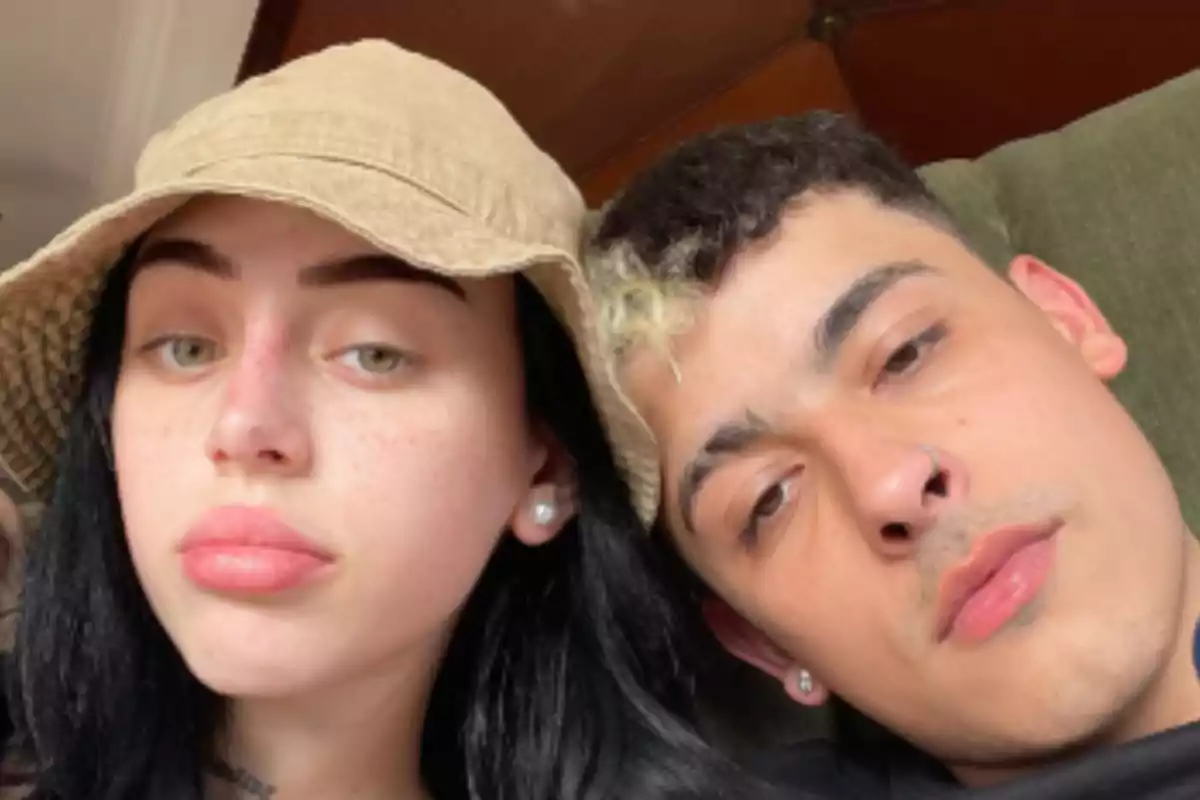 Dos personas jóvenes posan juntas para una selfie, una de ellas lleva un sombrero beige y la otra tiene un mechón rubio en el cabello oscuro Dos personas jóvenes posan juntas para una selfie, una de ellas lleva un sombrero beige y la otra tiene un mechón rubio en el cabello oscuro