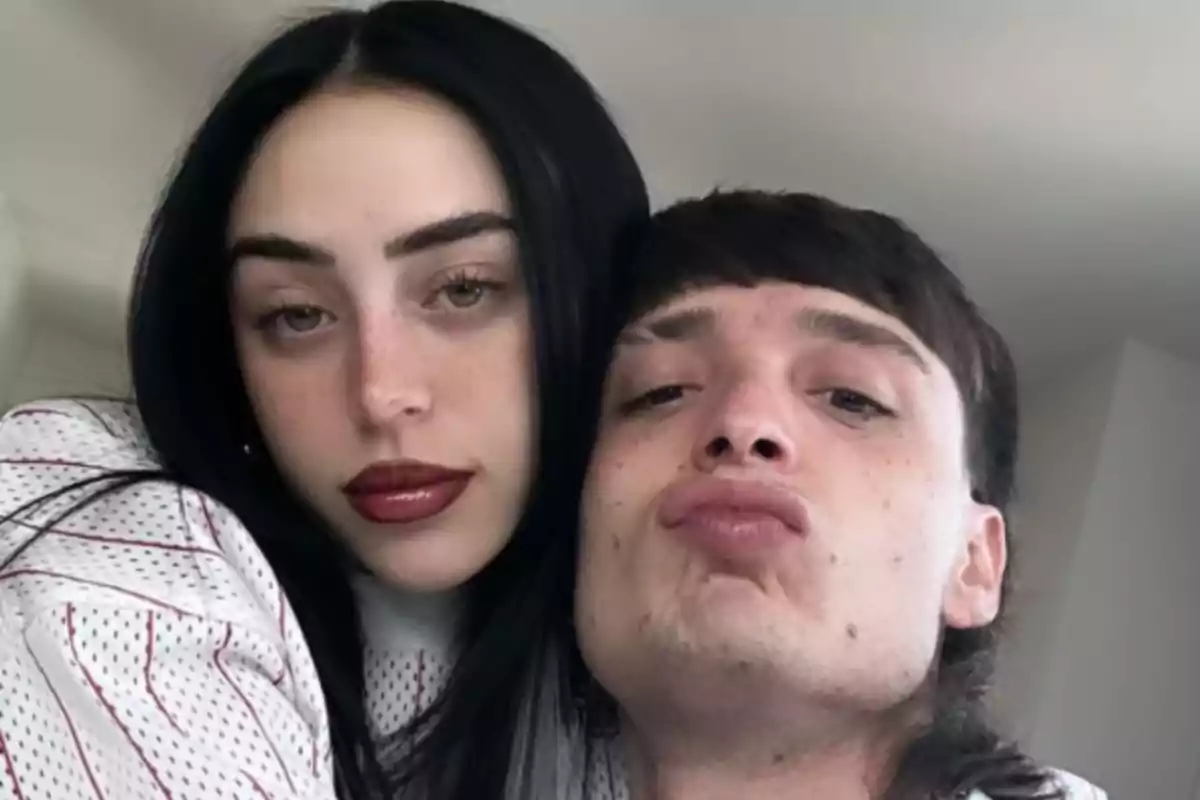 Dos personas jóvenes posan juntas para una selfie, una de ellas con el cabello largo y oscuro y la otra haciendo un gesto de beso con los labios. Dos personas jóvenes posan juntas para una selfie, una de ellas con el cabello largo y oscuro y la otra haciendo un gesto de beso con los labios.