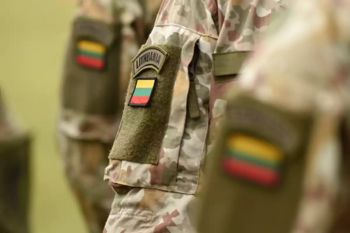Uniformes militares con camuflaje y parches de Lituania en los brazos de los soldados