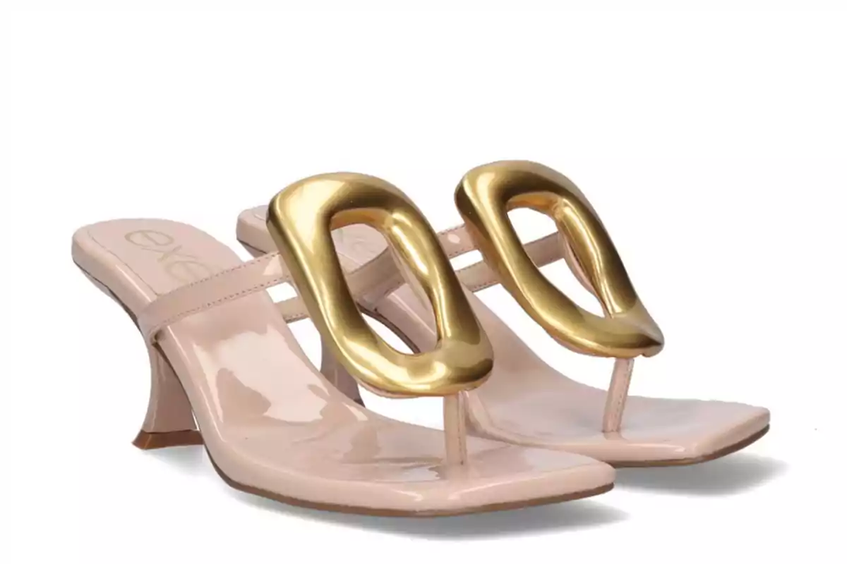 Nude mid-heel sandals with a large gold embellishment on the top and a square toe. Nude mid-heel sandals with a large gold embellishment on the top and a square toe.