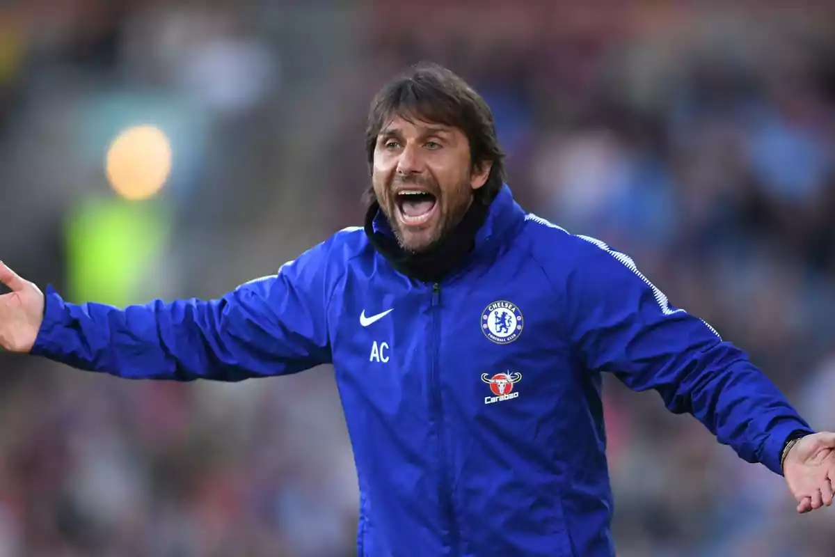 Entrenador de fútbol con chaqueta azul del Chelsea gesticulando y gritando durante un partido Entrenador de fútbol con chaqueta azul del Chelsea gesticulando y gritando durante un partido