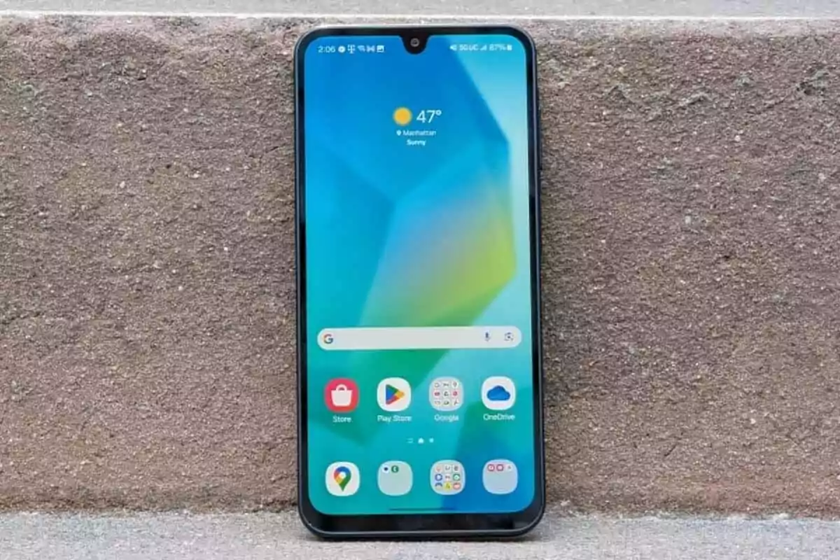 Smartphone resting on a concrete surface displaying the home screen with various apps and the weather in Manhattan Smartphone resting on a concrete surface displaying the home screen with various apps and the weather in Manhattan