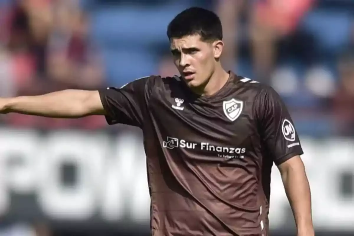 Soccer player in a brown uniform pointing with his arm during a match Soccer player in a brown uniform pointing with his arm during a match