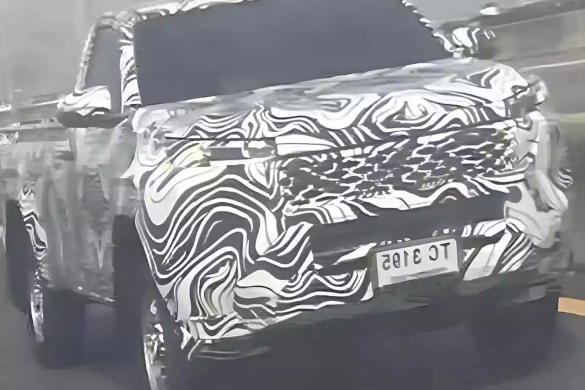 Camioneta cubierta con camuflaje de patrones abstractos en una carretera Camioneta cubierta con camuflaje de patrones abstractos en una carretera