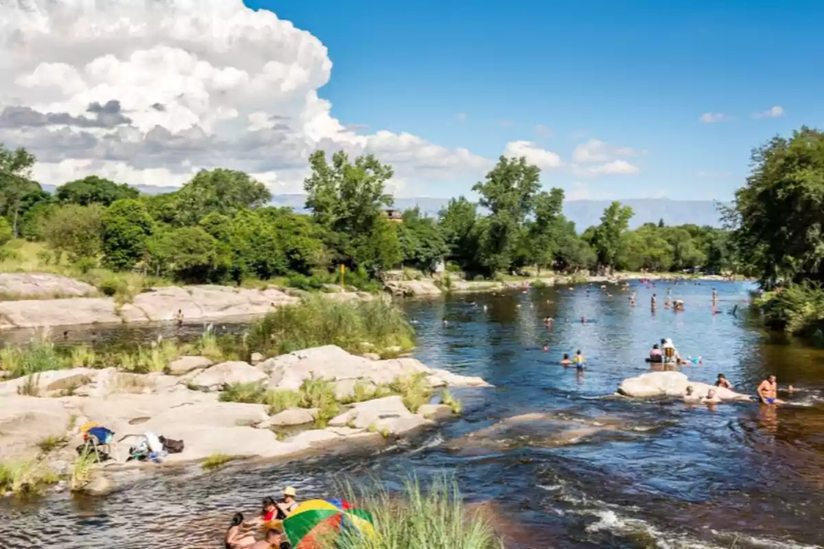 People enjoying a sunny day on a river surrounded by vegetation and rocks People enjoying a sunny day on a river surrounded by vegetation and rocks
