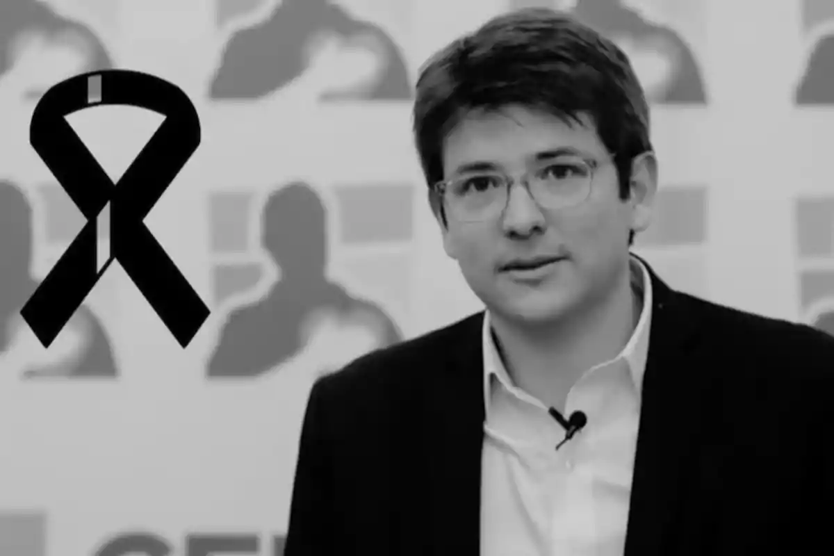 Hombre joven con gafas y cinta de luto negra en una imagen en blanco y negro