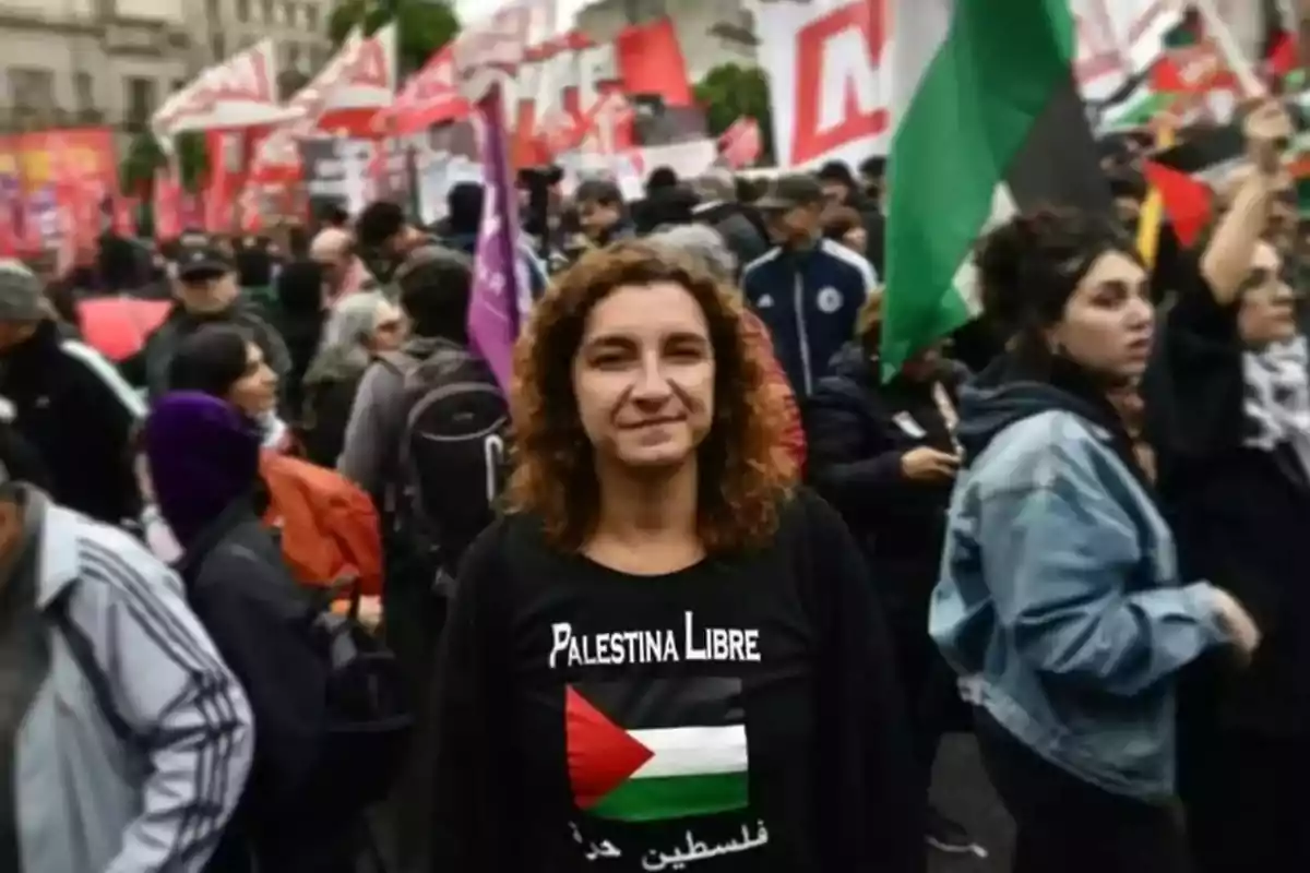 Mujer con camiseta de apoyo a Palestina en una manifestación rodeada de personas y banderas