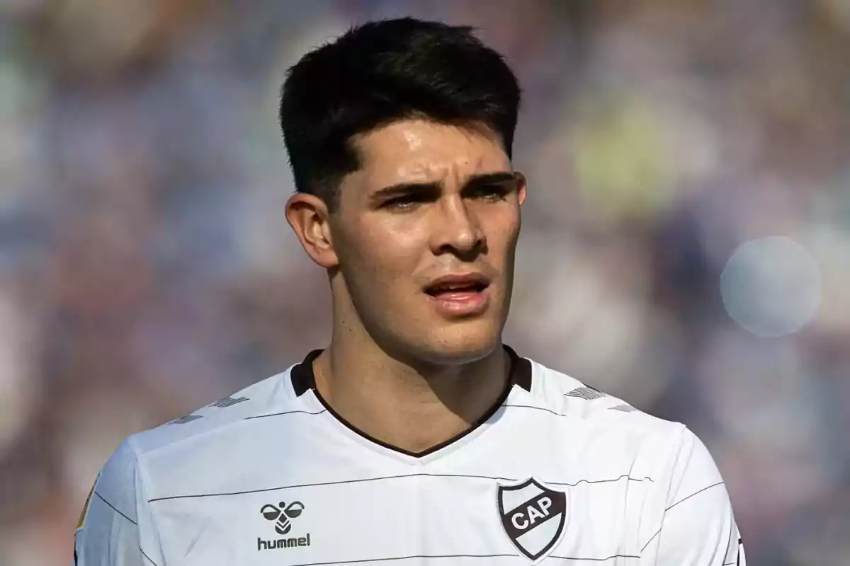 Soccer player wearing a white Club Atlético Platense jersey in a stadium during a match Soccer player wearing a white Club Atlético Platense jersey in a stadium during a match