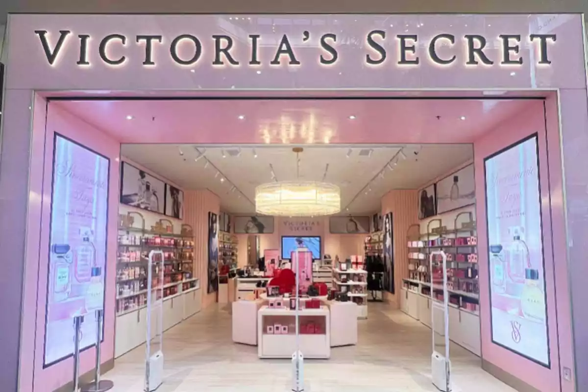 Tienda de Victoria's Secret con decoración en tonos rosados y estantes llenos de productos de belleza y fragancias