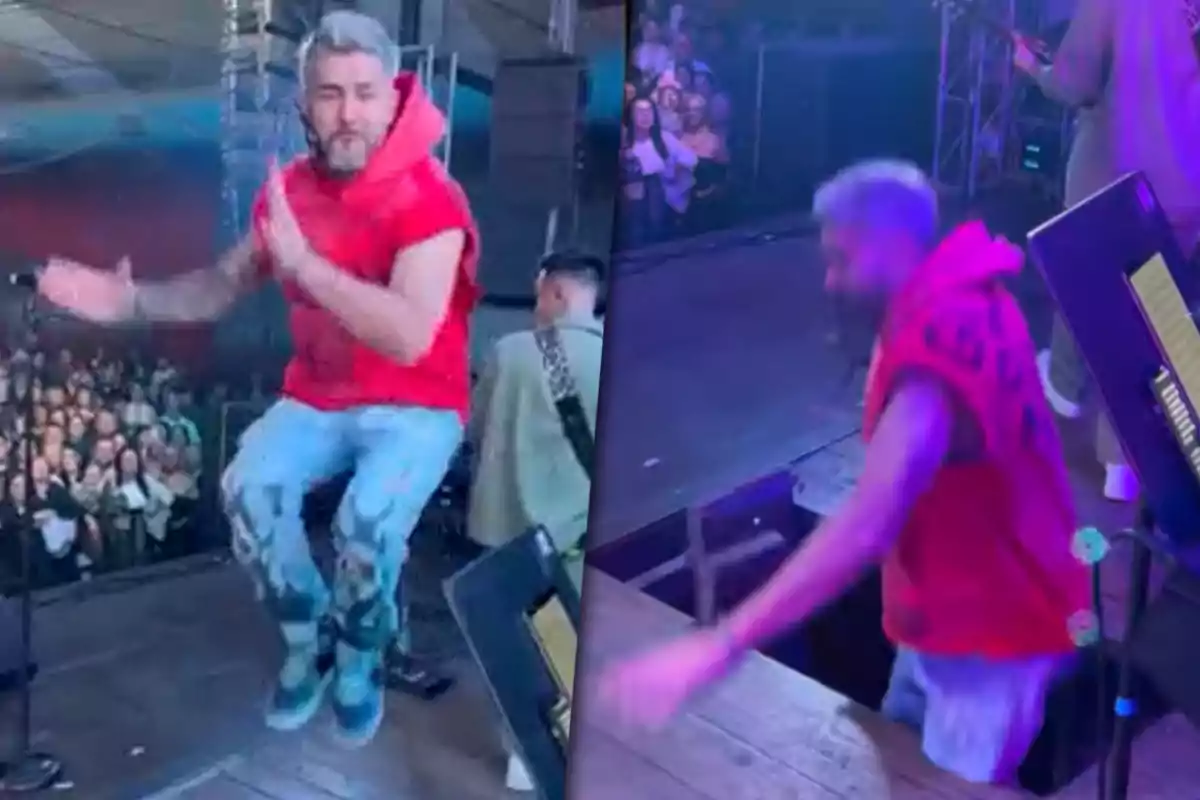 Un cantante con sudadera roja salta en el escenario y cae en un hueco mientras el público observa.