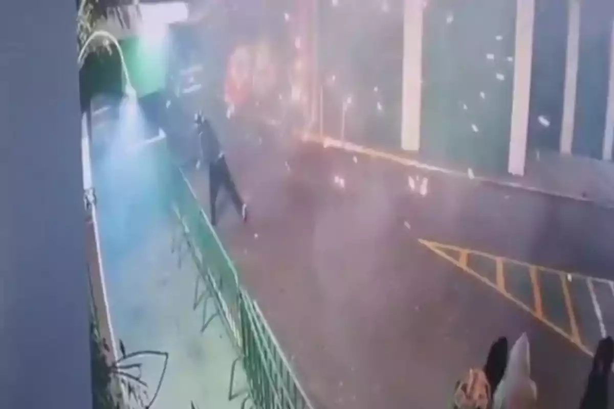 Persona corriendo en una calle mientras explotan fuegos artificiales a su alrededor