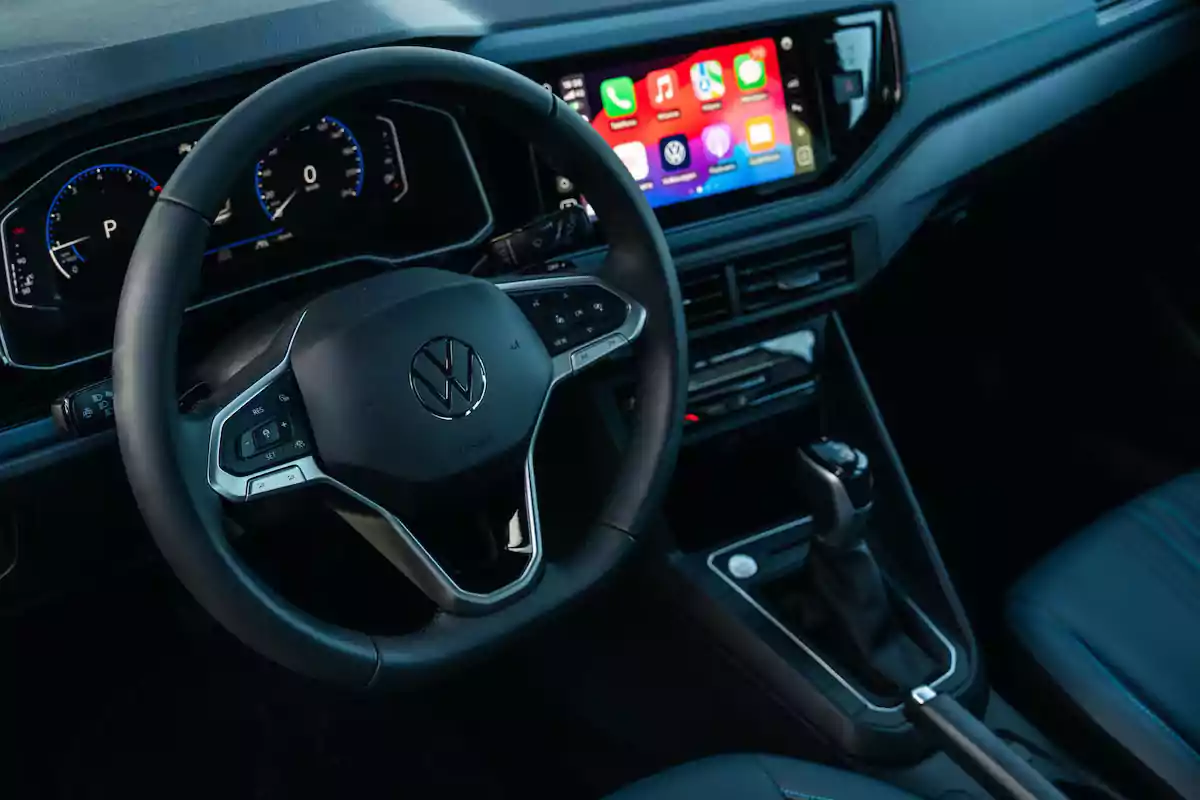 Interior de un automóvil Volkswagen con volante multifunción, tablero digital y pantalla central con sistema de infoentretenimiento encendido Interior de un automóvil Volkswagen con volante multifunción, tablero digital y pantalla central con sistema de infoentretenimiento encendido