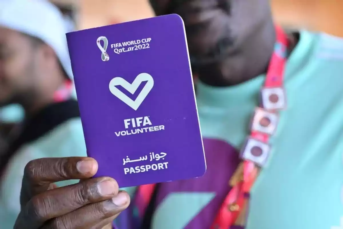 Persona sosteniendo un pasaporte morado de voluntario de la FIFA para la Copa Mundial Qatar 2022
