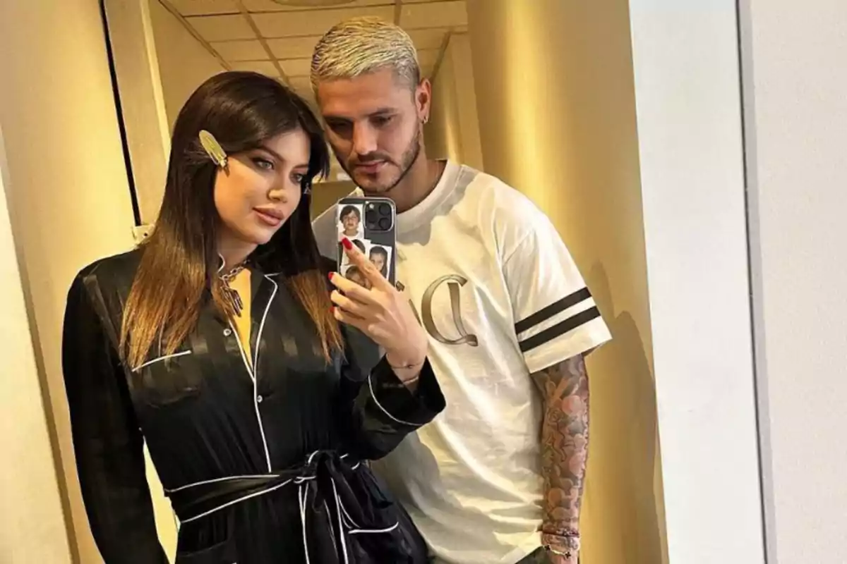 A woman in a black robe and a man in a white t-jersey pose together for a selfie in front of a mirror. A woman in a black robe and a man in a white t-jersey pose together for a selfie in front of a mirror.